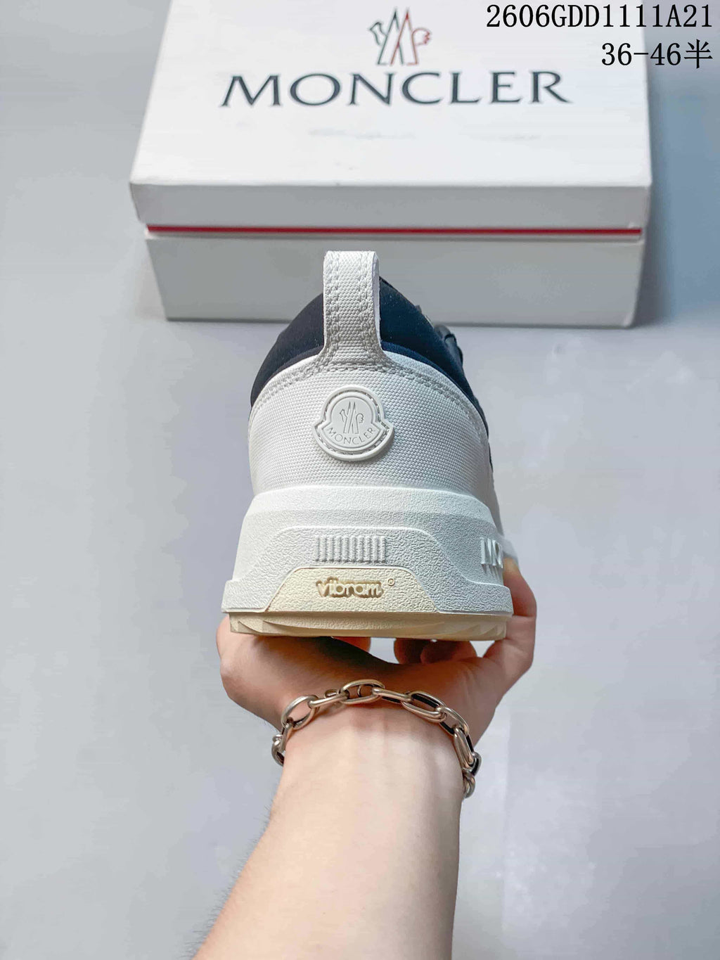 Rear view of a navy and white Moncler sneaker with heel logo and pull tab