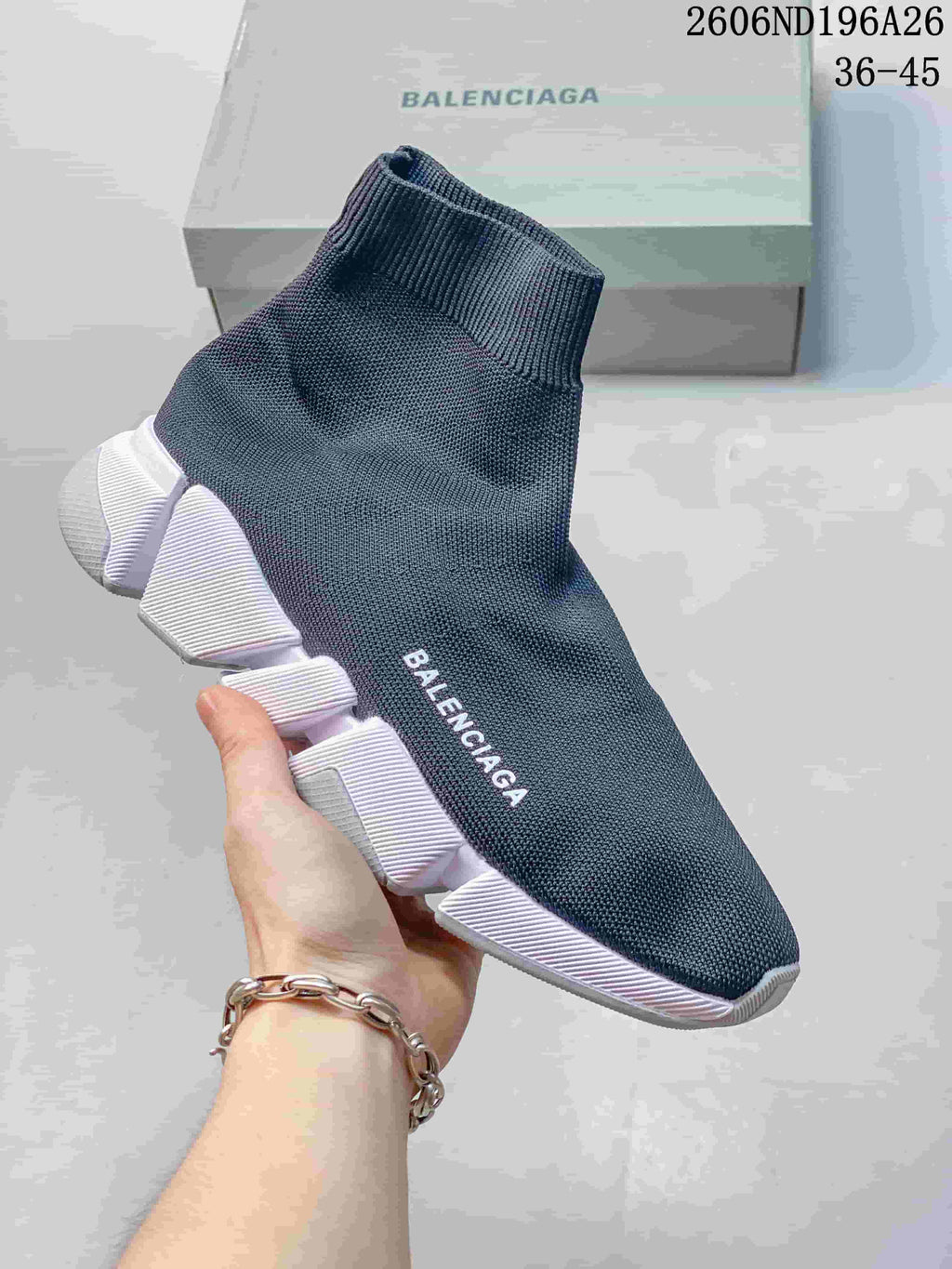 Dark blue sock-style knit sneaker with a white segmented sole and Balenciaga lettering