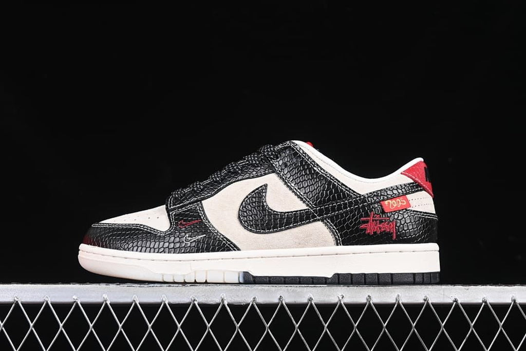 Side view of the black and sail sneaker with red detailing