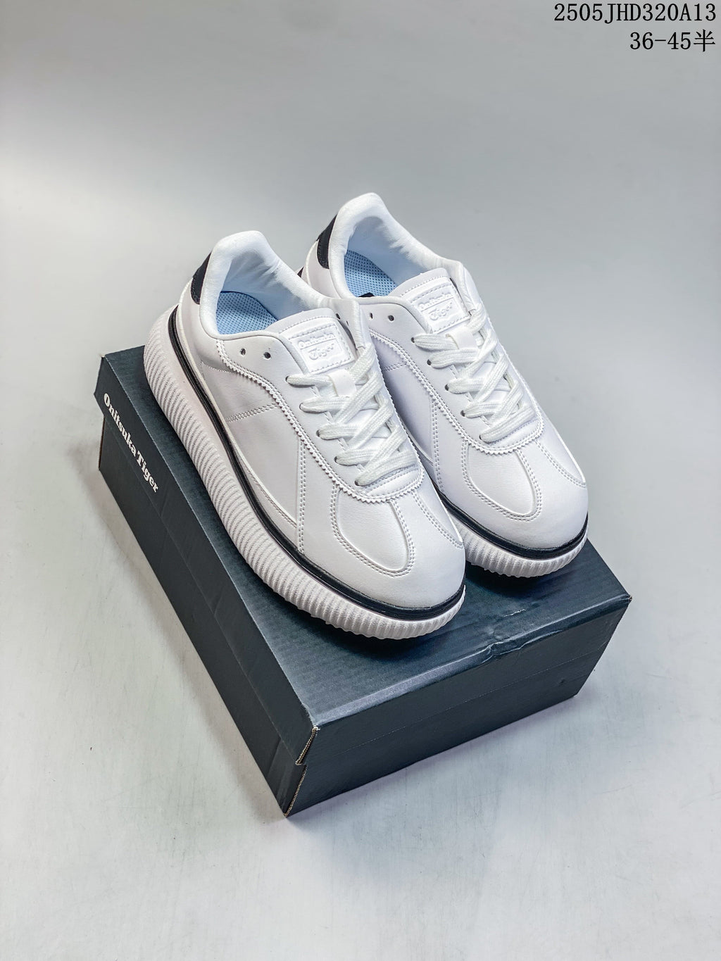 Pair of white Onitsuka Tiger Delecity low-top sneakers with black accents, shown on a shoebox.