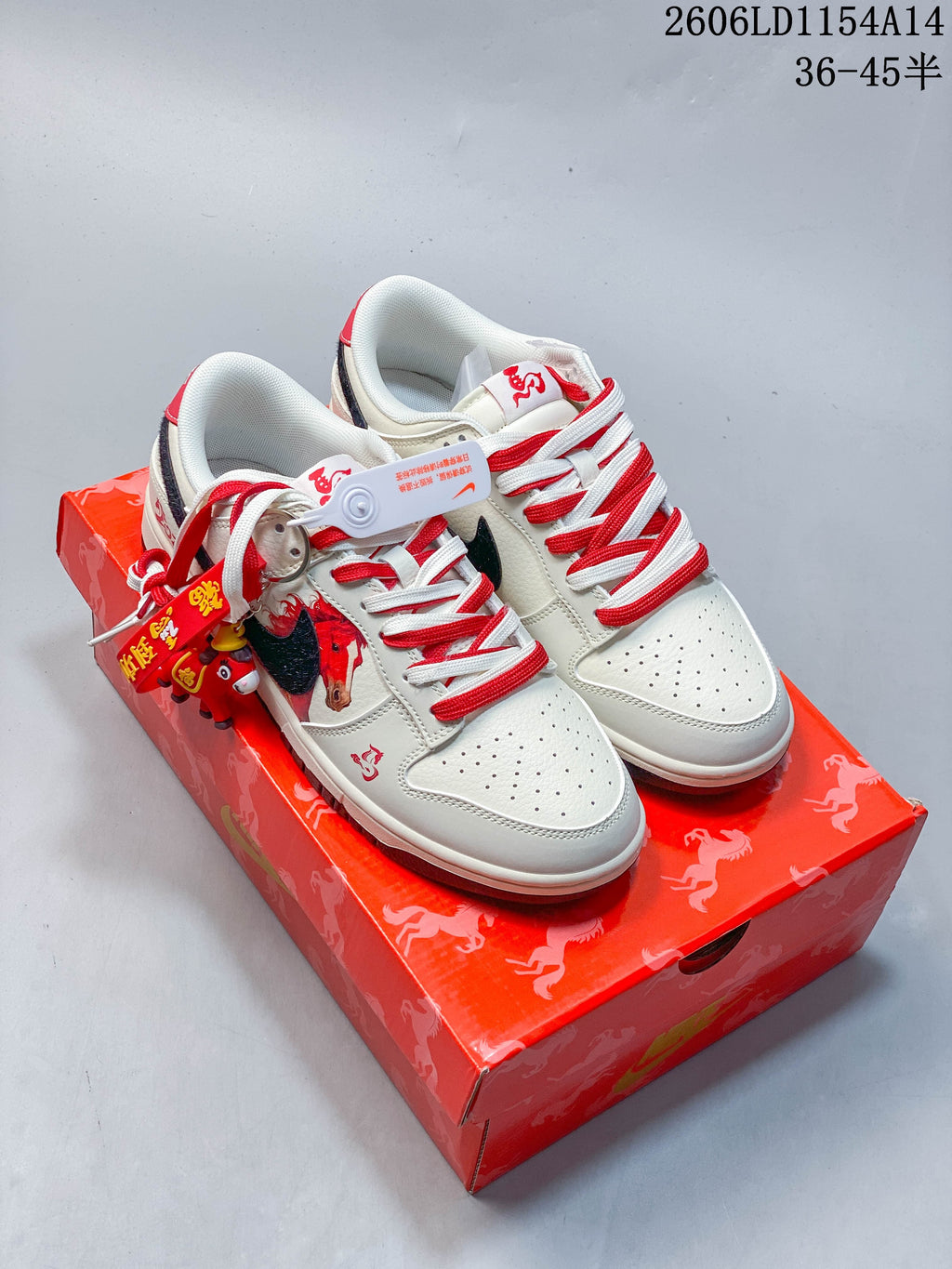 Pair of off-white Nike SB Dunk Low sneakers with horse graphics, red-and-white laces, and a red patterned shoe box