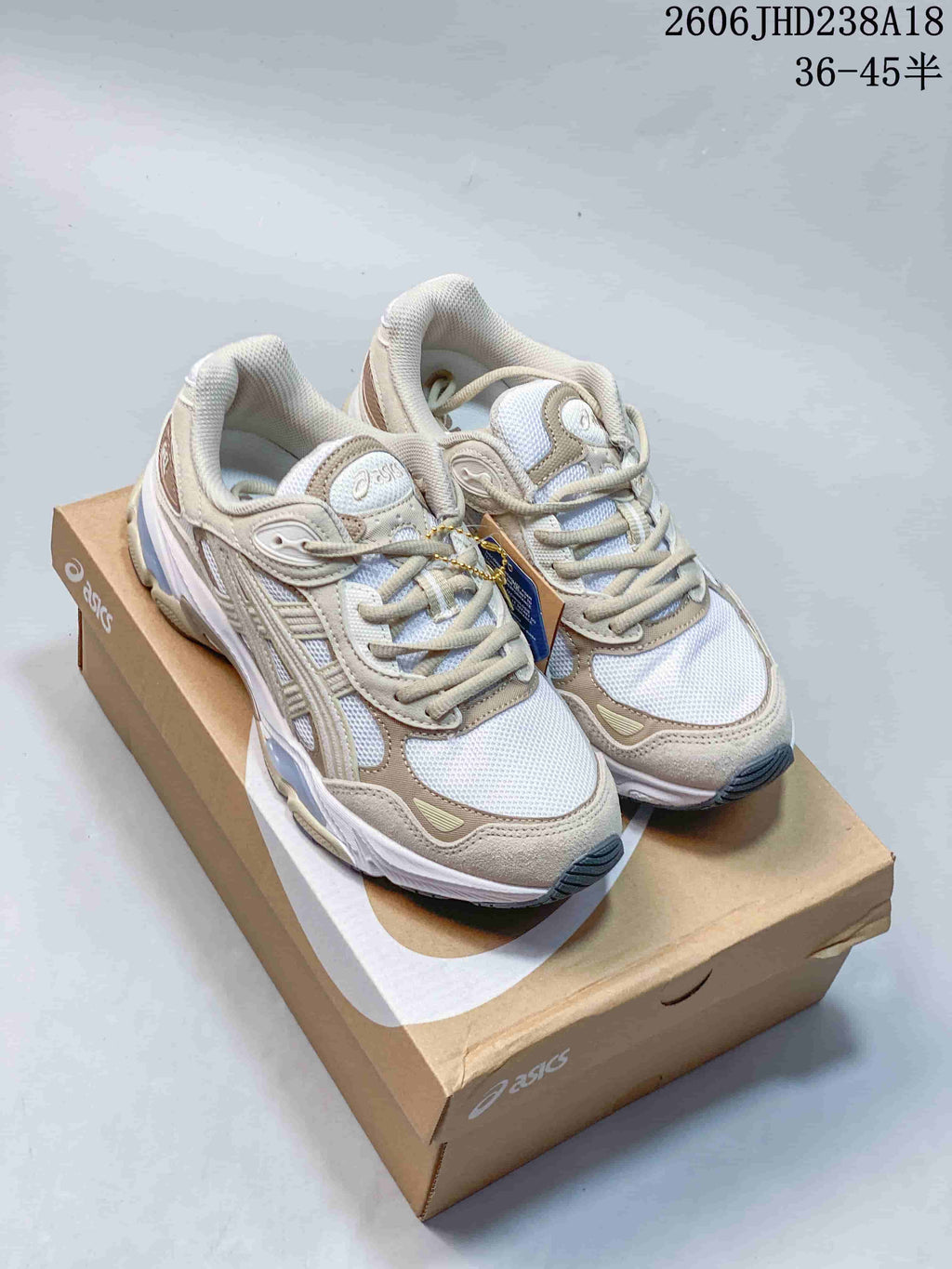 Pair of white and beige ASICS GEL-NYC 2.0 sneakers displayed on a shoebox