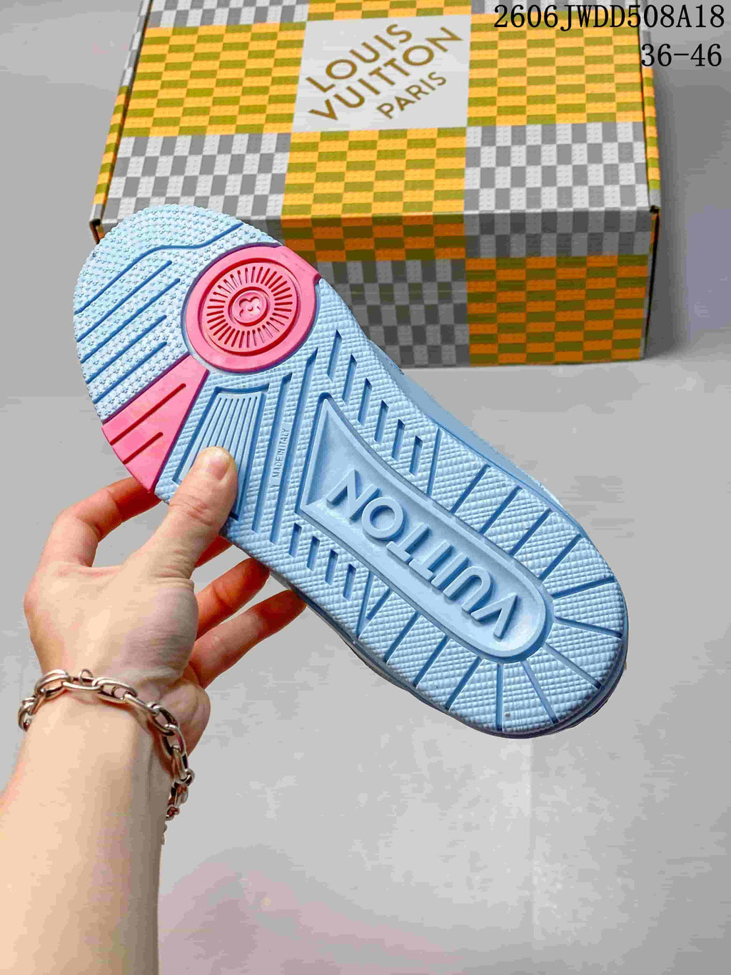 Blue sneaker outsole with textured tread and pink heel section