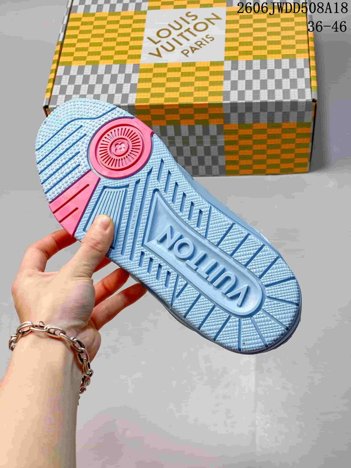 Blue sneaker outsole with textured tread and pink heel section