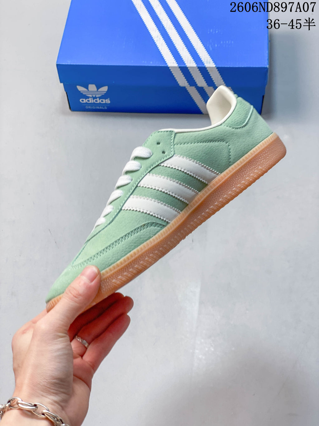Side view of the mint green adidas Samba with white stripes and gum-colored outsole
