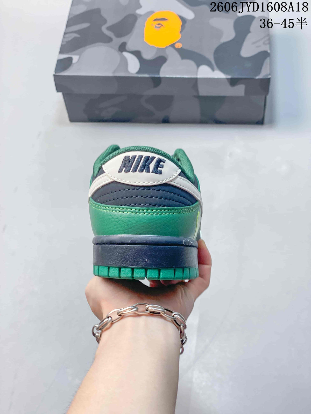 Rear view showing green and navy heel panels and an off-white heel tab