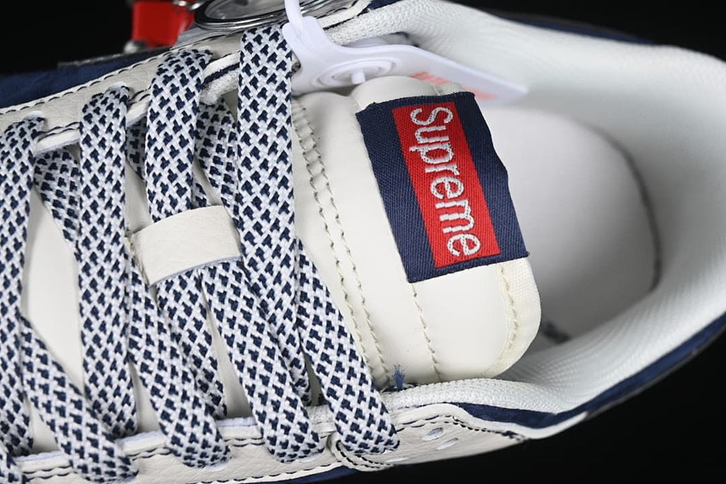 Close-up of patterned laces and a Supreme tongue label.