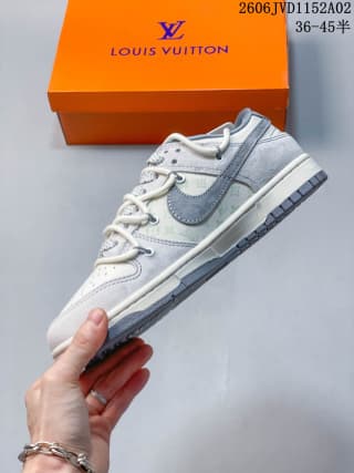 Side profile of a gray and white low-top sneaker showing the contrasting swoosh, layered panels, and textured outsole.