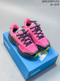 Pair of bright pink HOKA Challenger 8 shoes with black laces, yellow accents and dark soles on a blue shoebox.