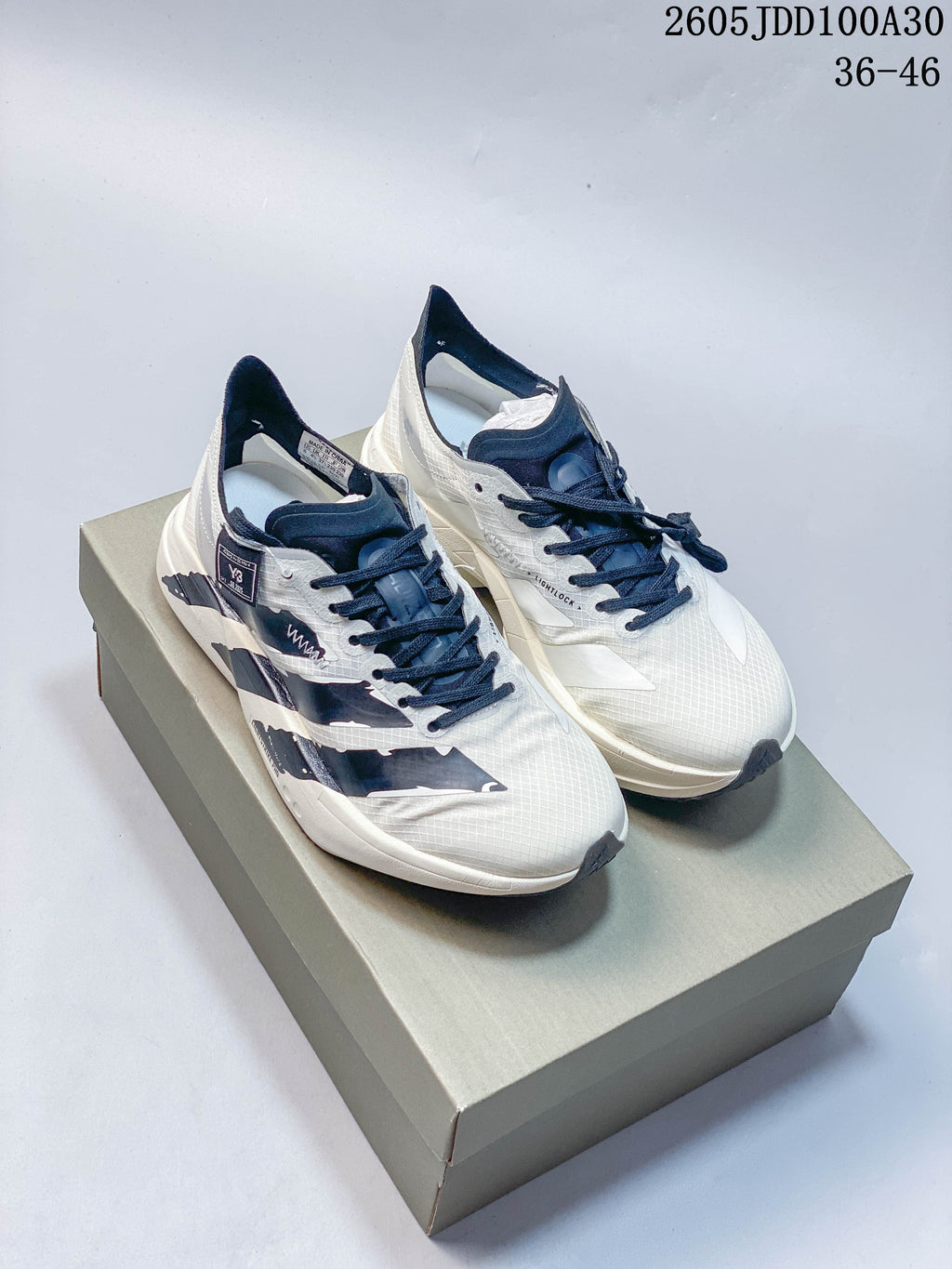 Pair of white and navy Adidas Adizero Adios Pro 4 running shoes shown on a box