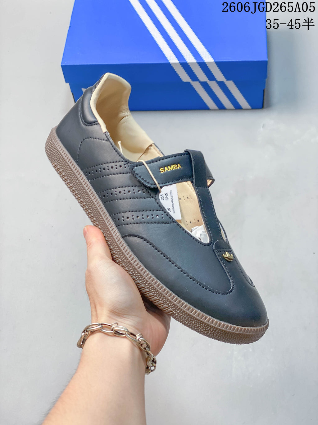 Angled side view of a dark adidas Samba Jane sneaker with perforated stripes and a gum-colored sole