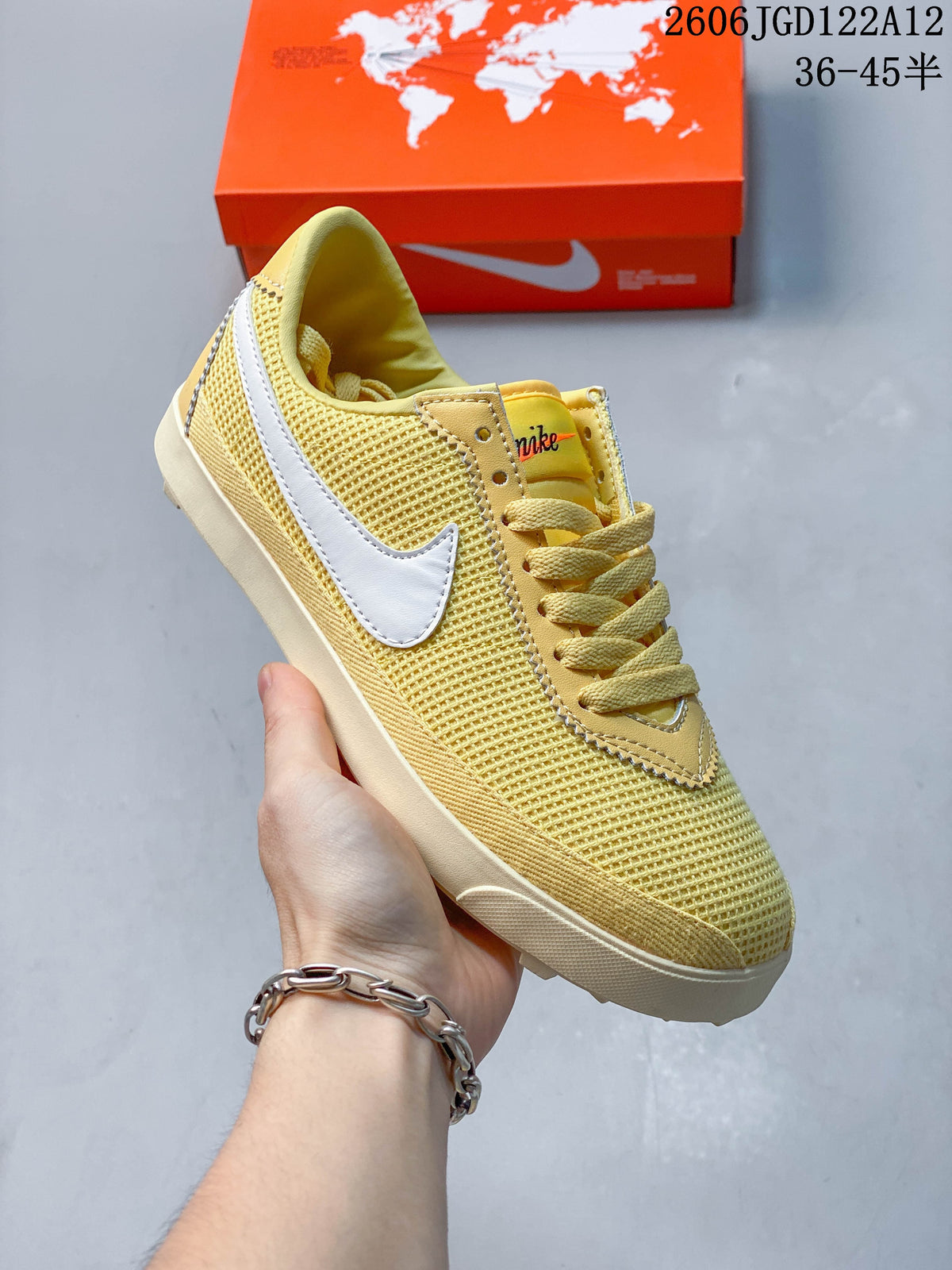 Close side view of a pale yellow Nike Astro Grabber sneaker with white Swoosh detailing and matching laces.