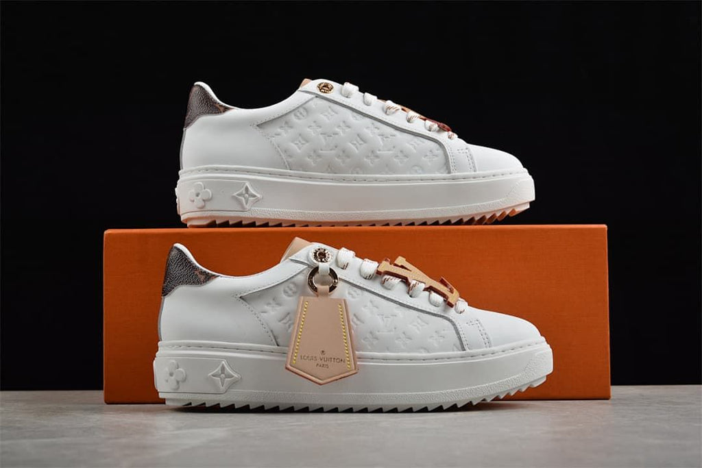 Pair of white low-top platform sneakers displayed with a box