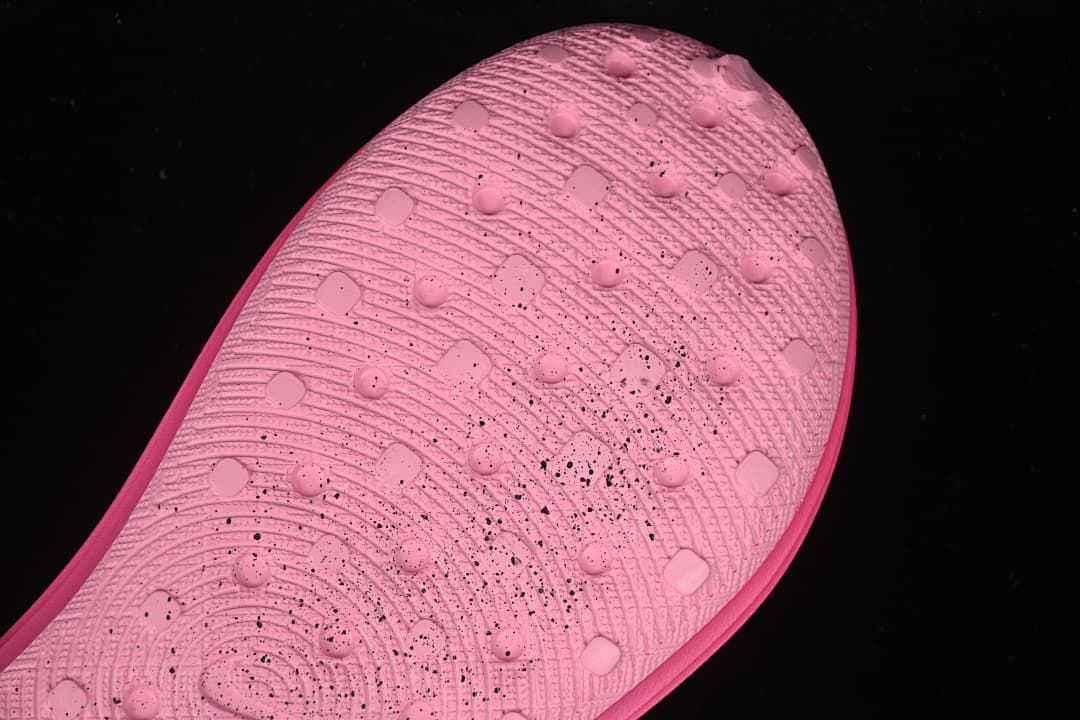 Close-up of the pink clog outsole showing textured grooves and raised traction details.