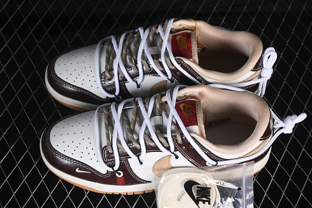 Pair of cream and dark brown low-top sneakers with layered laces and an extra pair of white laces