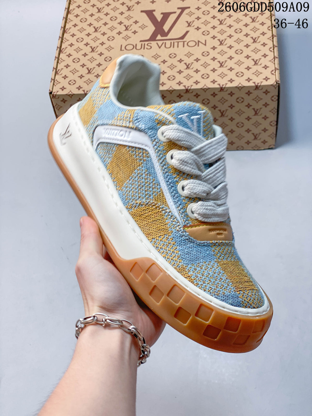 Angled side view of blue and tan check-patterned sneaker with white midsole and tan outsole.