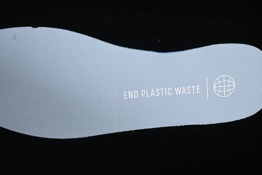Close-up of shoe insert printed with “END PLASTIC WASTE”