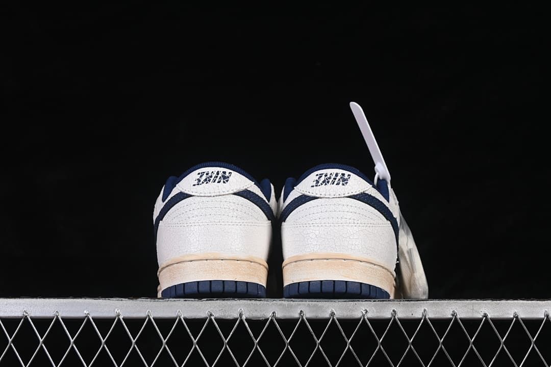 Rear view of both sneakers showing heel graphics and navy outsole edges