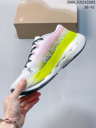 Side view of one sneaker showing the pink upper, bright neon yellow midsole section, white cushioning area, and visible On branding.
