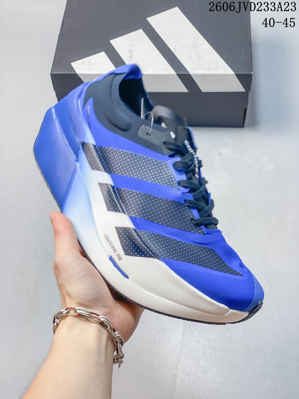 Side view of the blue running shoe showing Adidas stripes and a white midsole
