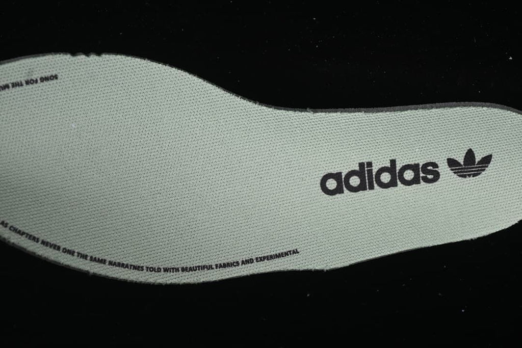 Removable insole with adidas Trefoil branding and printed text.