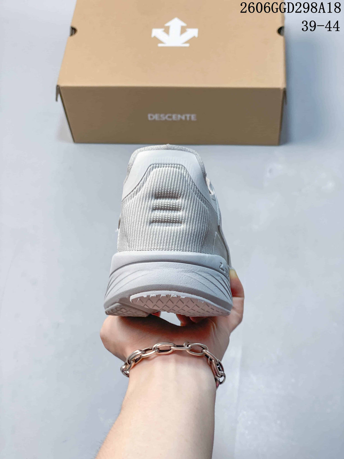 Rear view of the light gray sneaker showing the heel and outsole.