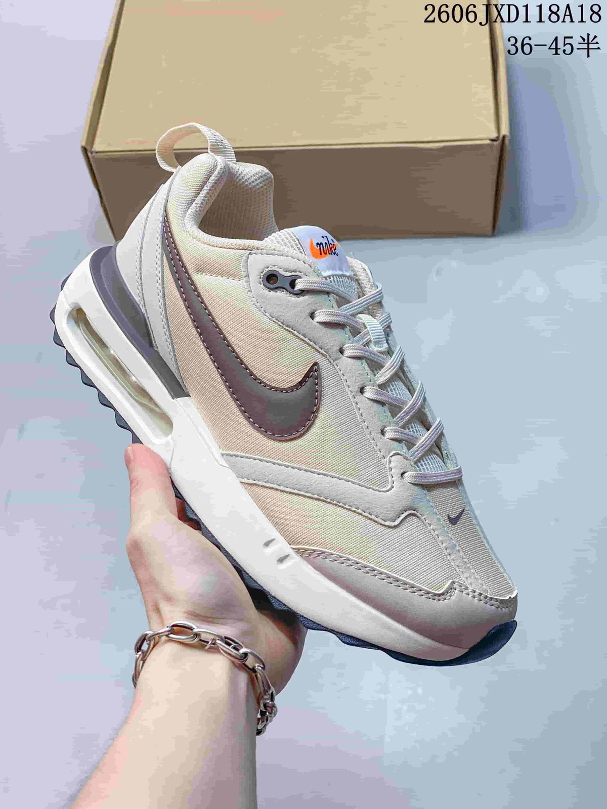 Angled side view of a light neutral Nike Air Max Dawn sneaker with contrasting Swoosh and visible heel Air unit
