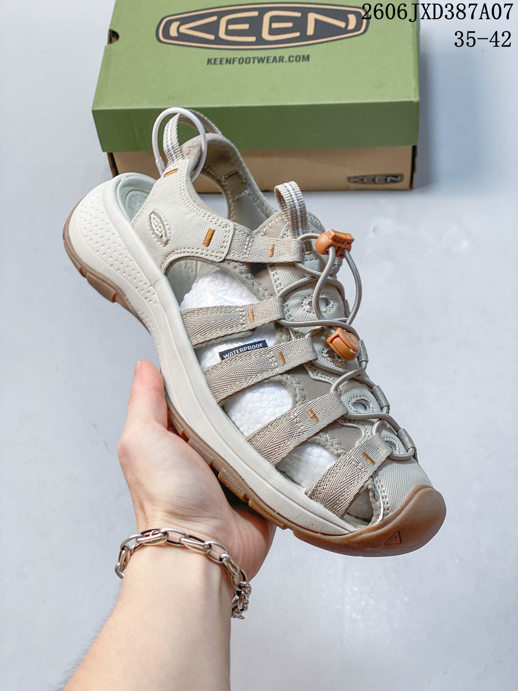 Angled view of the sandal showing the adjustable cord closure and protective toe; image overlay shows 35–42.