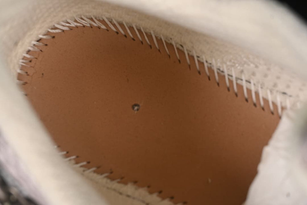 Close-up inside the sneaker showing the stitched construction beneath the footbed.