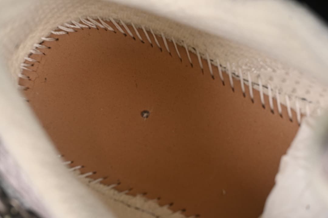 Close-up inside the sneaker showing the stitched construction beneath the footbed.