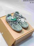 Pair of sage-green Miu Miu and New Balance sneakers with mesh panels, layered overlays and extra lace options, displayed on a box.