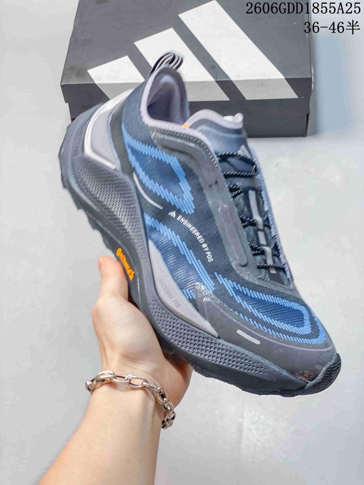Side view of a dark gray Adidas Holo Peak shoe with blue accents
