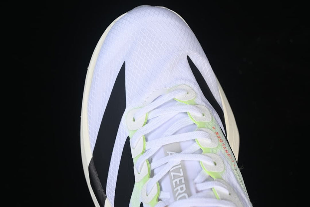 Top-down close-up of the toe and lacing on the white running shoe.