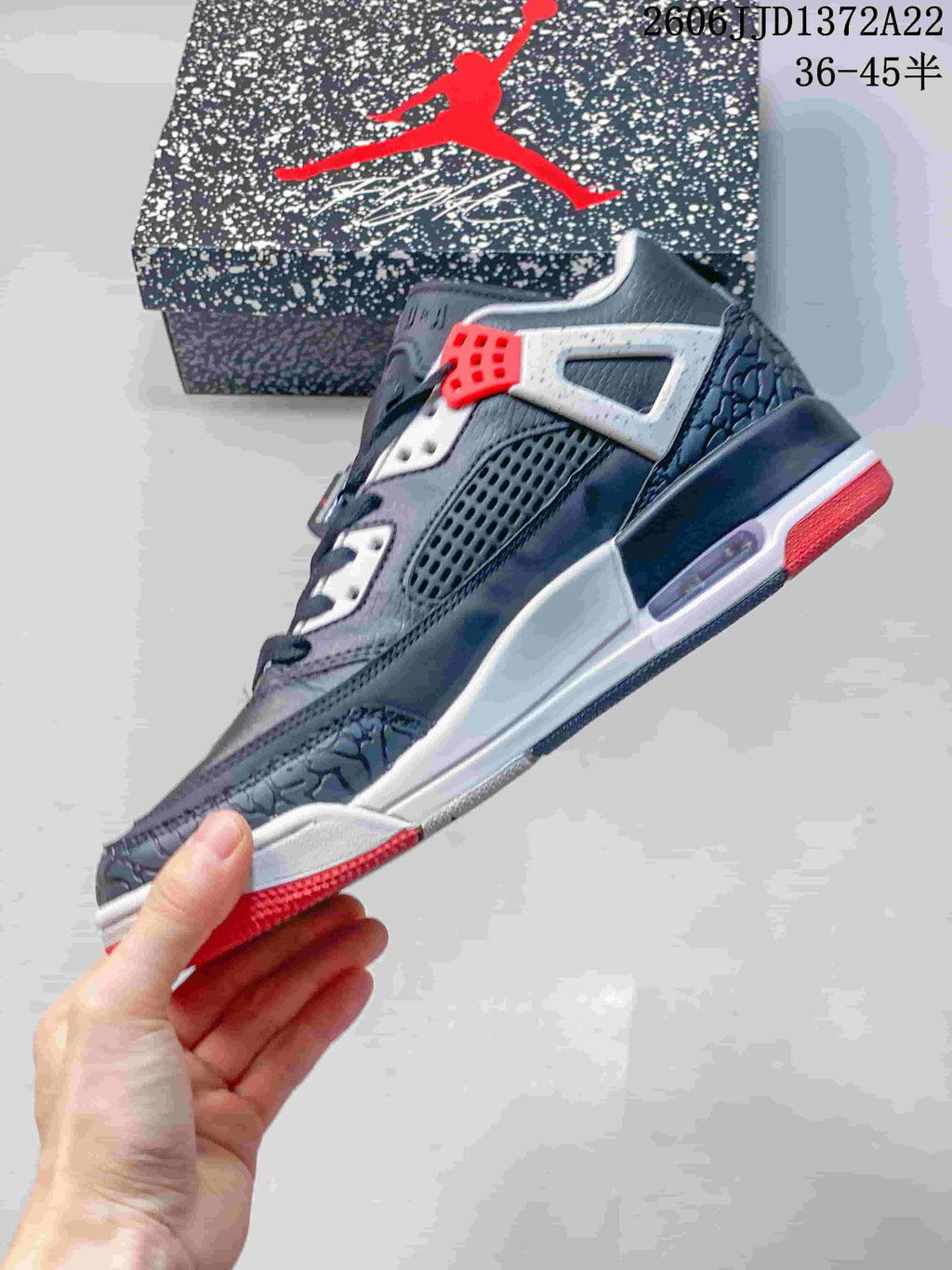 Side view of a charcoal Jordan Spizike Low sneaker with white and red accents