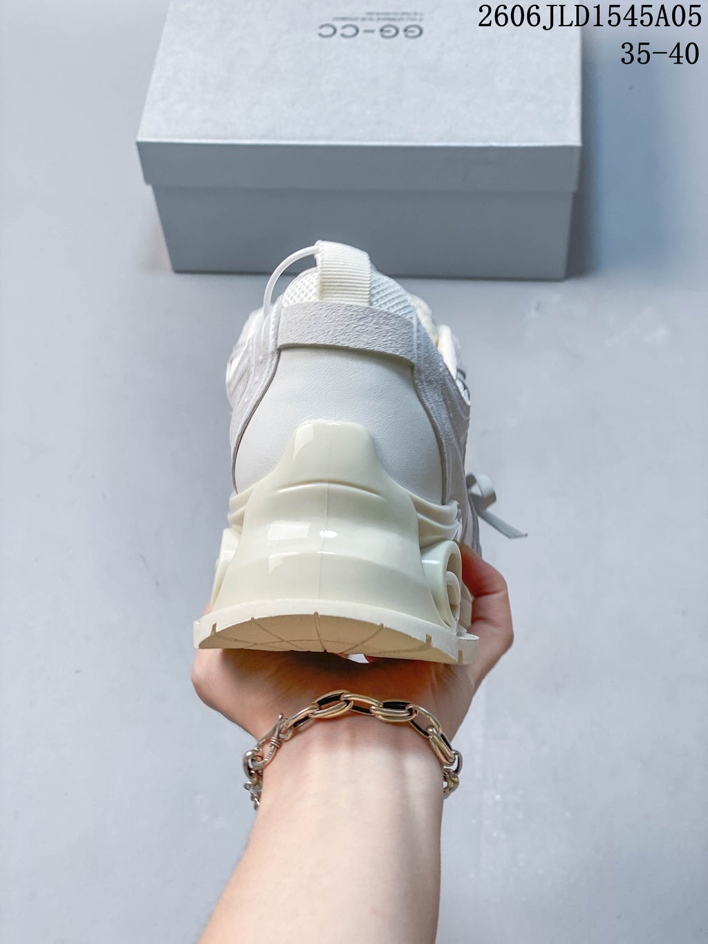 Rear view of a cream chunky sneaker with a sculpted heel and thick sole
