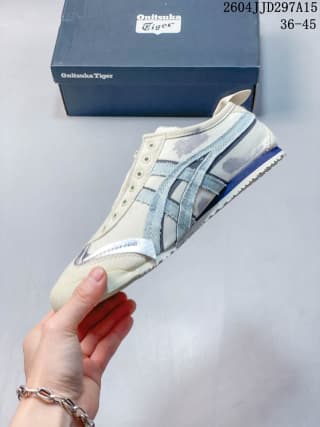 Side profile showing the blue Onitsuka Tiger stripes, cream upper, and rubber outsole.