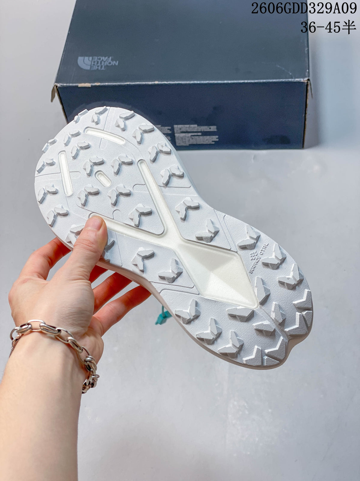 Close-up of the patterned outsole on a yellow and dark gray hiking shoe.