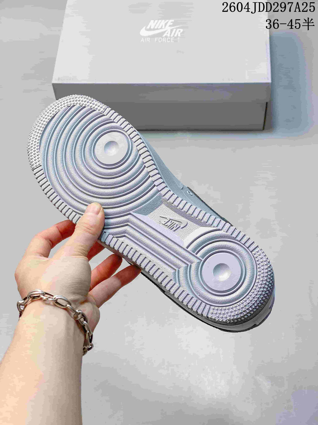 Underside of a Nike Air Force 1 sneaker showing its circular tread pattern and textured outsole.