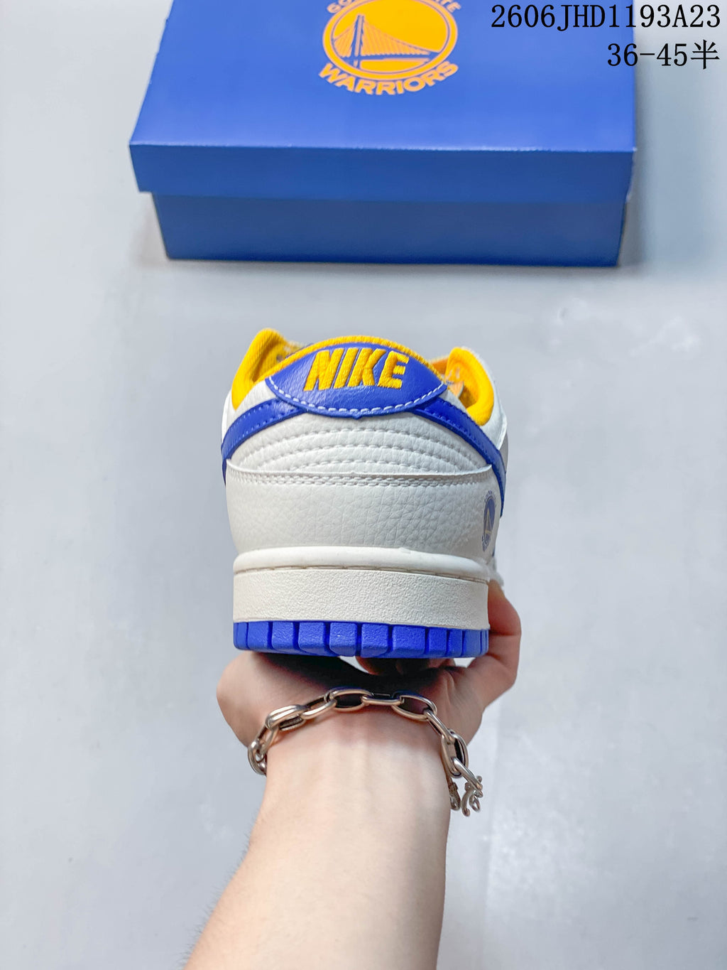 Rear view showing the blue heel tab, yellow lining, and white upper