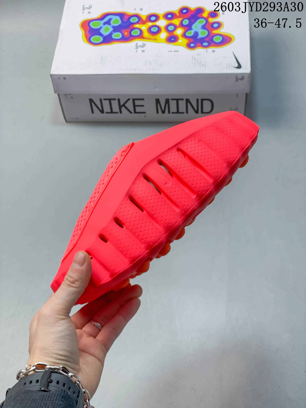 Side view of a bright red Nike Mind slide showing its perforated upper and sole profile.