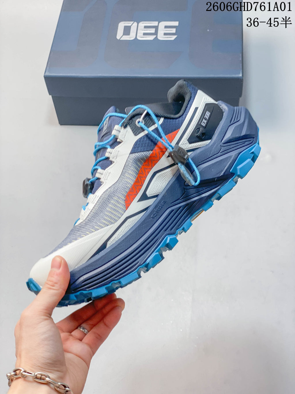 Side view of a gray and navy Kailas FUGA EX330 II trail running shoe with orange accents and blue laces.