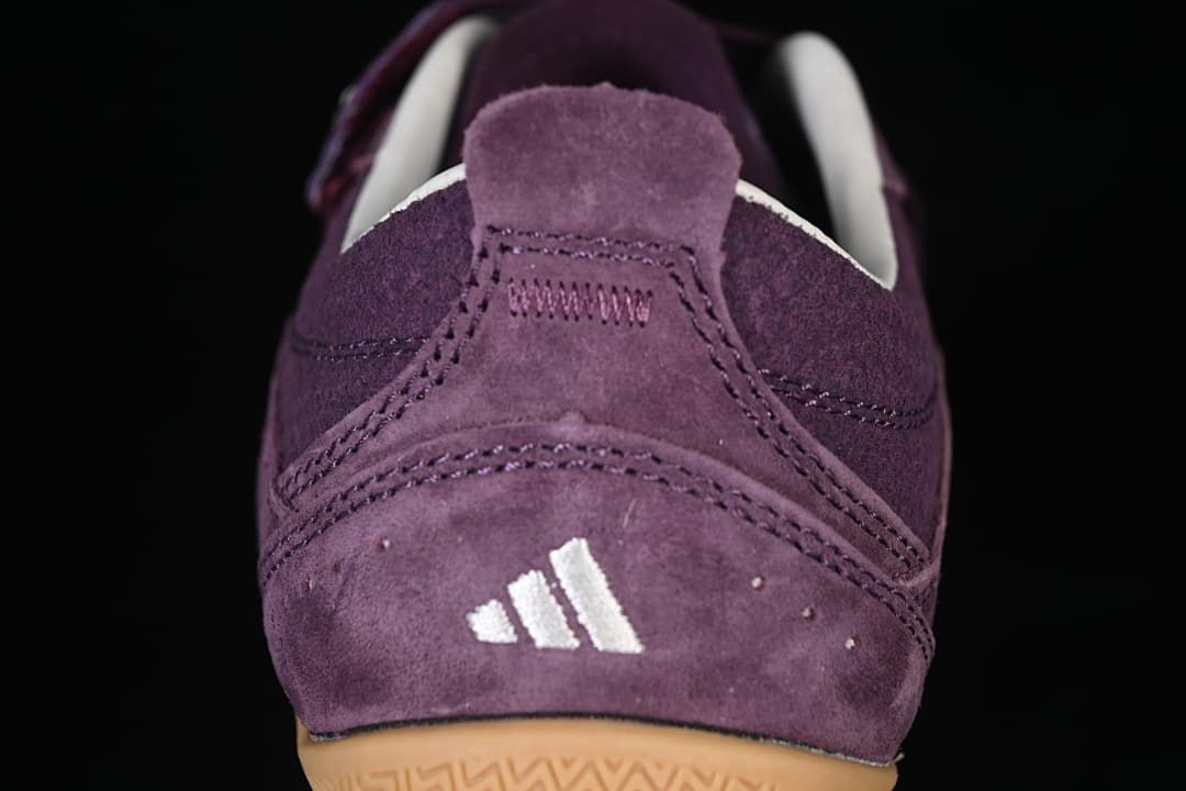 Rear close-up of the purple sneaker with white adidas logo and gum outsole