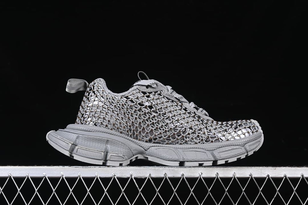 Side profile of the grey sneaker with openwork upper and sculpted sole.