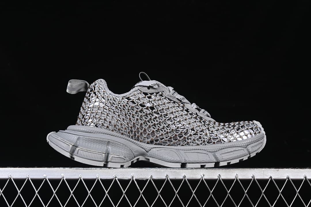 Side profile of the grey sneaker with openwork upper and sculpted sole.