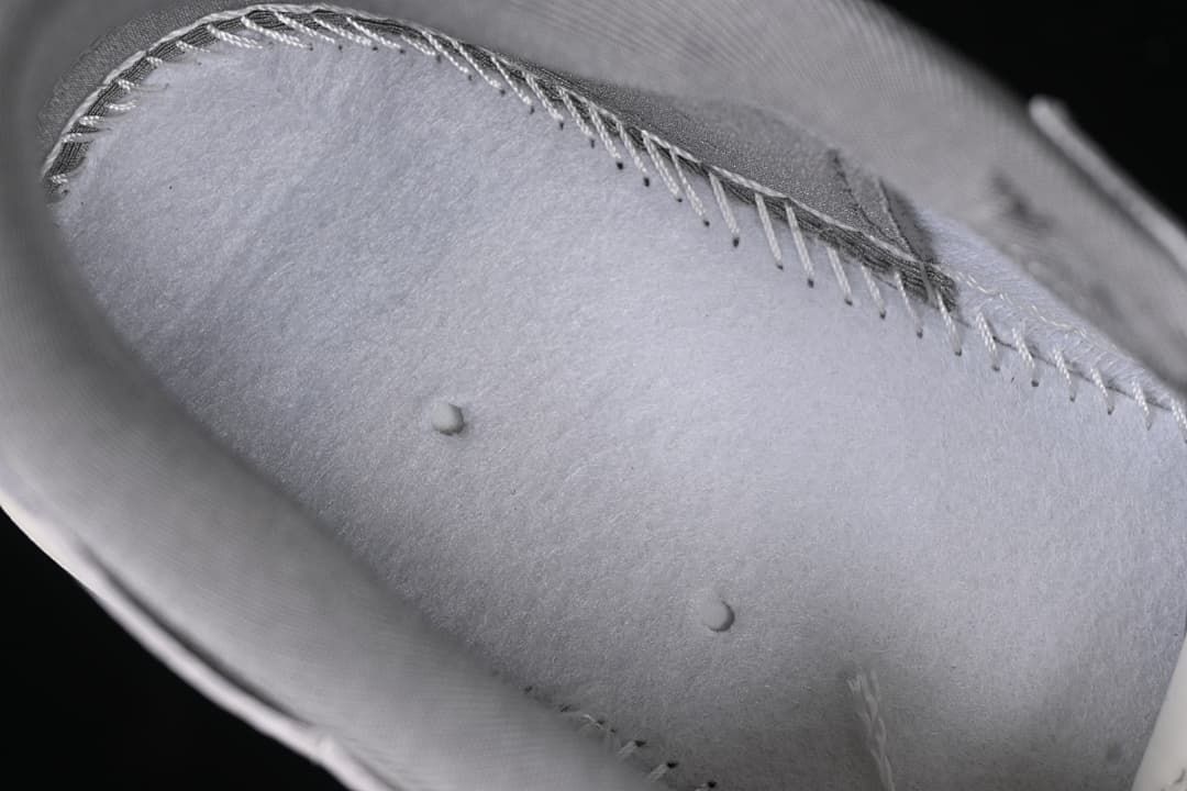 Close-up of stitching and surface details on a gray sneaker panel
