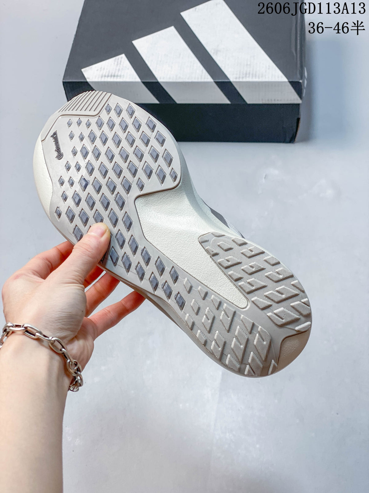 Close-up of the patterned outsole on a light-colored Adidas running shoe