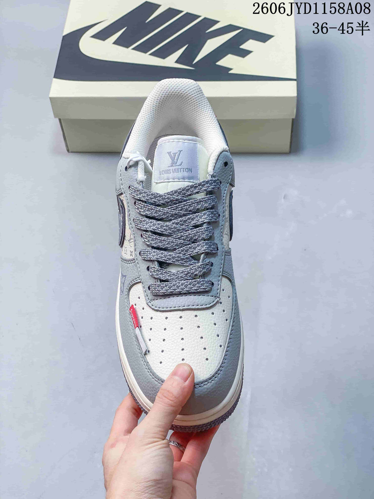 Top view of a gray and white lace-up sneaker with a perforated toe panel