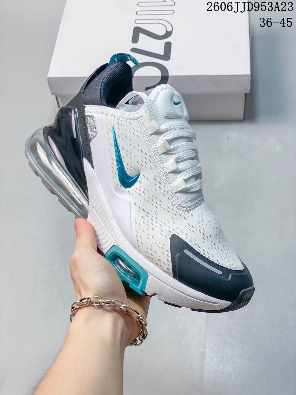 Angled side view of the white Nike Air Max 270 with teal Swoosh and dark heel accents.
