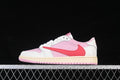 Side view of a pink, white, and red Jordan 1 Low sneaker against a black background.