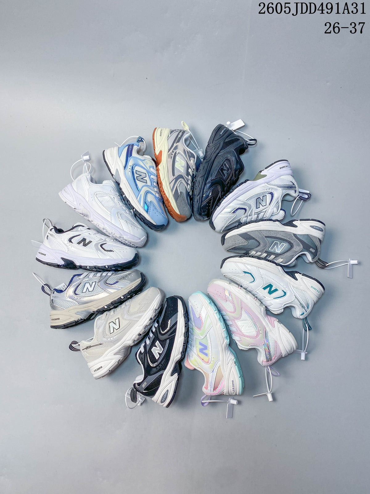 A group of kids' New Balance sneakers in assorted colors arranged in a circle.